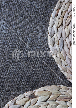 Two placemats made of water hyacinth on rough linen burlap. Two placemats made of water hyacinth on rough linen burlap. 132770535