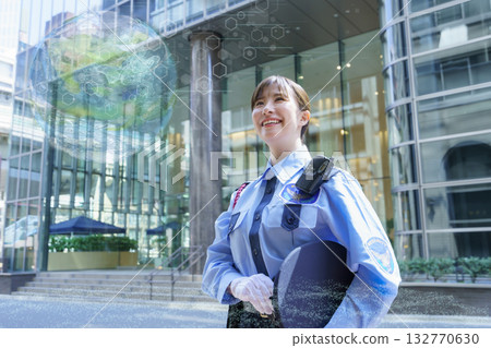 一名年輕的女保全站在辦公大樓前。照片由東京電子專門學校、電波學園株式會社提供。 132770630