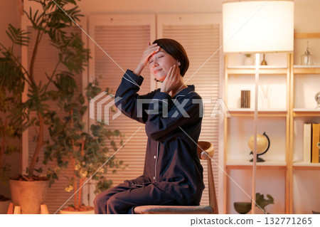 A woman doing skin care in her room at night A woman doing skin care in her room at night 132771265