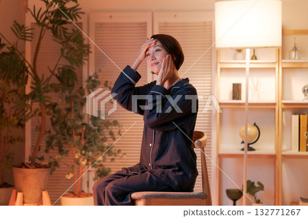 一位女士晚上在房間裡做護膚。 132771267
