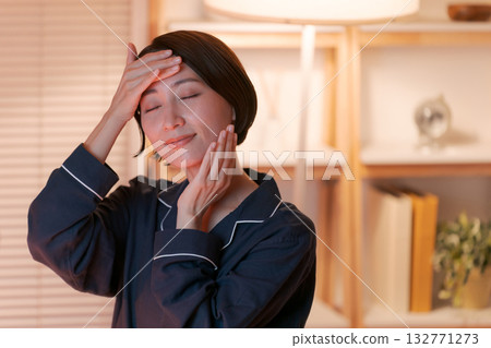 一位女士晚上在房間裡做護膚。 一位女士晚上在房間裡做護膚。 132771273