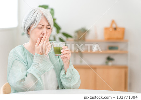 Senior women who drink green juice, green smoothies, and vegetable juice for health (dislikes it, tastes bad) Senior women who drink green juice, green smoothies, and vegetable juice for health (dislikes it, tastes bad) 132771394