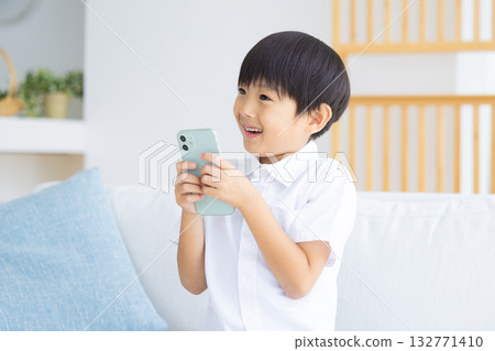 Boy looking at a smartphone Boy looking at a smartphone 132771410