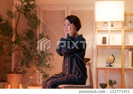 一位女士晚上在房間裡做護膚。 132771451