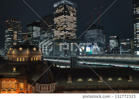 Tokyo Station illuminated by the setting sun, a shining business district at night, a businessman returning home from a night intersection Tokyo Station illuminated by the setting sun, a shining business district at night, a businessman returning home from a night intersection 132772325