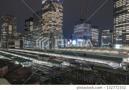 Tokyo Station illuminated by the setting sun, a shining business district at night, a businessman returning home from a night intersection Tokyo Station illuminated by the setting sun, a shining business district at night, a businessman returning home from a night intersection 132772332