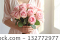 High-resolution image of a bouquet of pink roses held by a woman 132772977