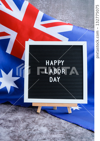 Australian flag and message board text HAPPY LABOR DAY festive holiday greetings. Concept of workers rights and public holiday, use in labor-themed marketing 132775075