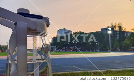 A water bottle with a black background and a blue running track A water bottle with a black background and a blue running track 132775985