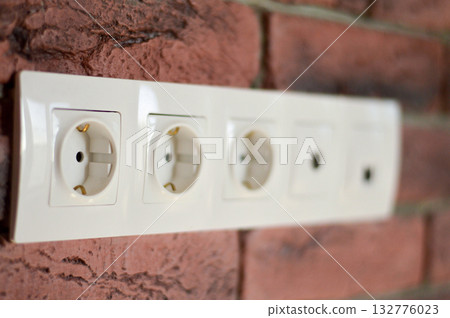 Electrical power socket on red brick wall background. 132776023