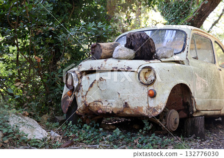 Vintage Car in Nature, Abandoned and Rusty, with Wood and Stones on the Hood, a Nostalgic Scene in a Forest, Perfect for Travel and Adventure Concepts Vintage Car in Nature, Abandoned and Rusty, with Wood and Stones on the Hood, a Nostalgic Scene in a Forest, Perfect for Travel and Adventure Concepts 132776030