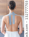 Kinesiology tape applied to the neck and shoulder area of a woman. Physical therapy and muscle support through modern rehabilitation techniques 132777703