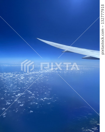 Airplane wing, blue sky and sea 132777918