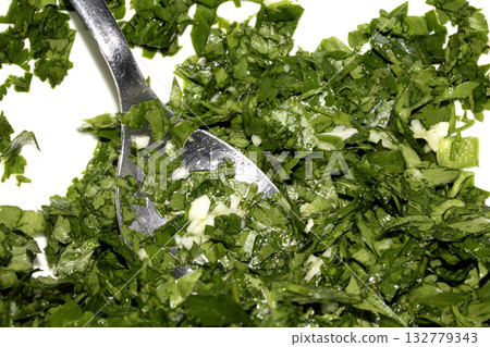Close up of chopped coriander and parsley herbs on a white background 132779343