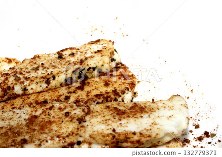 Close up of seasoned halloumi cheese ready to be grilled on white background Close up of seasoned halloumi cheese ready to be grilled on white background 132779371