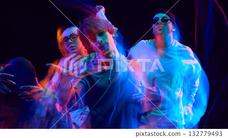 Hip hop dancers illuminated by neon blur in expressive motion 132779493