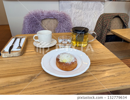 Morning tea and pastry served at a cozy cafe table. Relaxation, warmth and balance in urban lifestyle and simple pleasures. 132779634