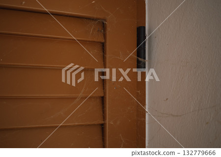 Thick cobwebs covering old window shutters, signaling a serious need for professional cleaning Thick cobwebs covering old window shutters, signaling a serious need for professional cleaning 132779666