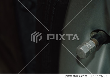 Close-up of a car tire valve stem nipple used for air pressure inflation 132779705