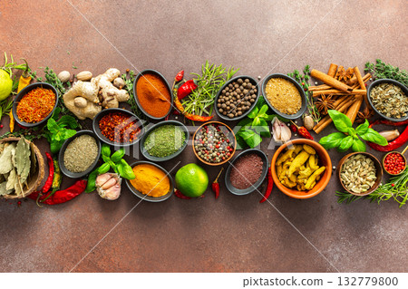 A stunning spread of fresh spices and herbs, meticulously arranged on a deep brown backdrop, capturing their vibrant colors and tantalizing aromas A stunning spread of fresh spices and herbs, meticulously arranged on a deep brown backdrop, capturing their vibrant colors and tantalizing aromas 132779800