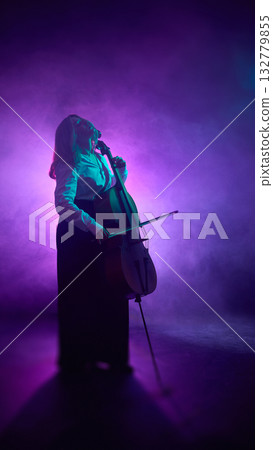 Cellist performing with concentration under magenta light and smoke Cellist performing with concentration under magenta light and smoke 132779855