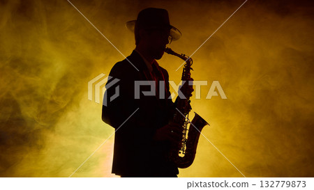 Jazz saxophonist in hat performing with golden stage smoke Jazz saxophonist in hat performing with golden stage smoke 132779873