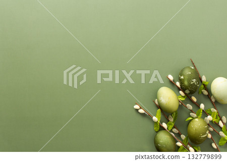 Colorful Easter eggs in shades of green are displayed alongside delicate branches adorned with flowers, set against a soft green backdrop, evoking a spring celebration Colorful Easter eggs in shades of green are displayed alongside delicate branches adorned with flowers, set against a soft green backdrop, evoking a spring celebration 132779899