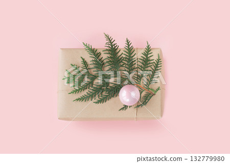 Christmas pink gift box with evergreen branches on pink background. Top view. 132779980