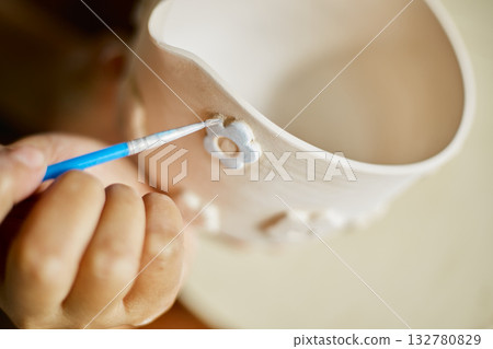 Close up hand of woman painting her pottery ceramic Close up hand of woman painting her pottery ceramic 132780829