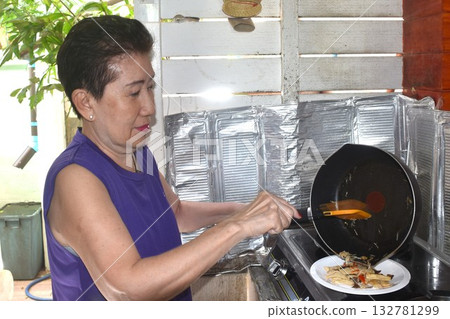 elder woman cooking and eating breakfast in home on morning elder woman cooking and eating breakfast in home on morning 132781299