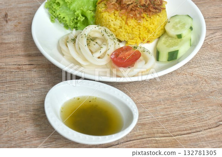 slice boiled squid and biryani rice cooked with curry on plate dipping sweet chili sauce   132781305
