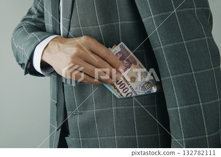 man putting Hungarian forints in pocket 132782111