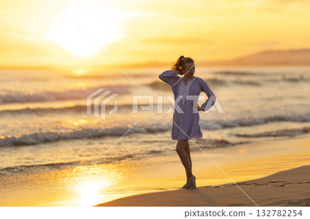 Woman enjoying golden sunset on tropical beach Woman enjoying golden sunset on tropical beach 132782254