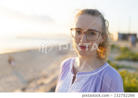 Young woman enjoying sunset on a beach vacation Young woman enjoying sunset on a beach vacation 132782266