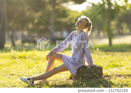 Young woman relaxing in nature enjoying warm sunlight Young woman relaxing in nature enjoying warm sunlight 132782288