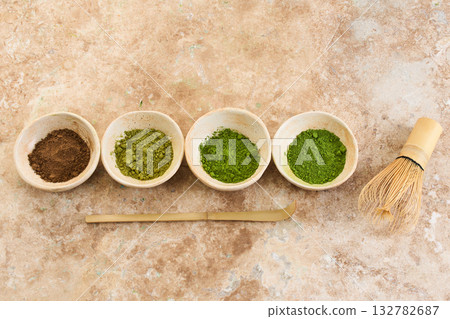 Matcha Tea Ceremony Set, Overhead view of matcha bowls, bamboo whisk, and scoop on a textured surface. Matcha Tea Ceremony Set, Overhead view of matcha bowls, bamboo whisk, and scoop on a textured surface. 132782687