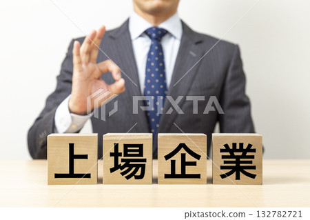 一位商人擺出「OK」的姿勢，旁邊立著一塊寫著「上市公司」的牌子。 132782721