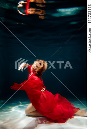 Mysterious female figure beneath water with swirling red cloth Mysterious female figure beneath water with swirling red cloth 132783118
