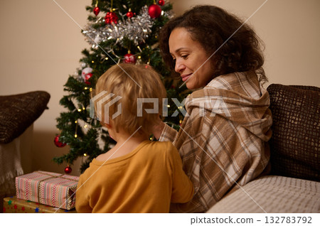 Mother And Child Share Cozy Christmas Moment By The Tree With Gifts At Home 132783792