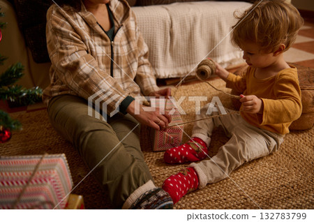 Family Christmas Gift Wrapping Moment With Child And Parent On Cozy Living Room Rug 132783799