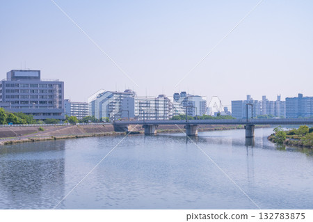 A calm river, bridges, and a cityscape of high-rise apartment buildings A calm river, bridges, and a cityscape of high-rise apartment buildings 132783875