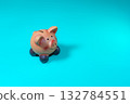 A piggy bank sits on a bright, solid blue background, ideal for concepts like saving money and finance. 132784551