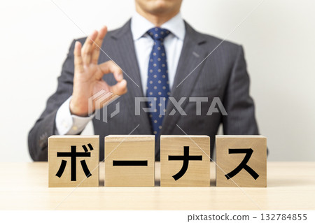 A businessman making an OK pose with a block that says "bonus" A businessman making an OK pose with a block that says "bonus" 132784855