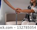 Caregiver supporting Asian older adult with walking stick providing compassionate nursing care for rehabilitation and well being at home 132785054