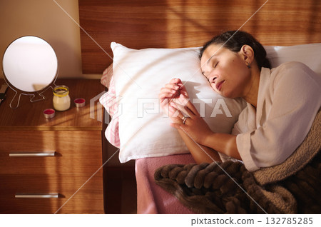 Sleeping Woman Resting In Bed With Lamp On Nightstand And Cozy Blanket Sleeping Woman Resting In Bed With Lamp On Nightstand And Cozy Blanket 132785285