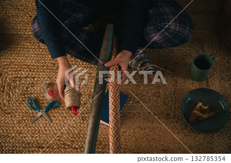 Cozy Crafting Moment: Person Wrapping Gifts With Decorative Paper and Supplies Cozy Crafting Moment: Person Wrapping Gifts With Decorative Paper and Supplies 132785354