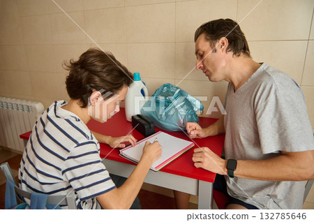 Two Men Studying At A Red Table, Writing In A Notebook During A Morning Session 132785646