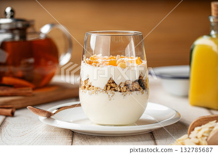 Yogurt dessert with granola and apricots in glass Yogurt dessert with granola and apricots in glass 132785687
