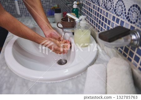Hands Washing at Bathroom Sink With Soap Dispenser and Towel on Marble Counter Hands Washing at Bathroom Sink With Soap Dispenser and Towel on Marble Counter 132785763