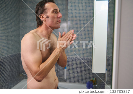 Athletic Man In Bathroom Prays With Hands Together By Mirror During Grooming Moment 132785827